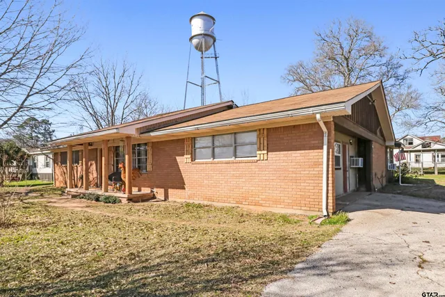 a front view of a house with a yard covered in snow