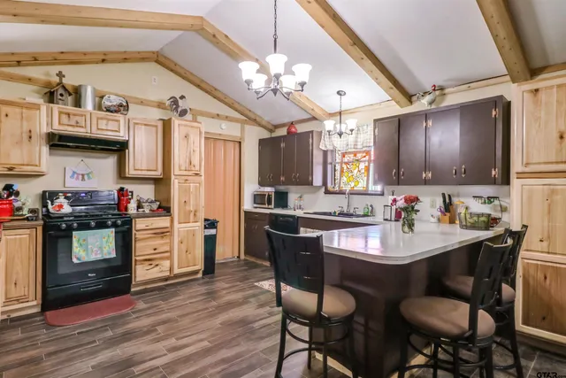 a kitchen with kitchen island granite countertop a sink cabinets and stainless steel appliances