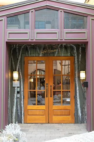 a front view of a building with glass windows and a tree