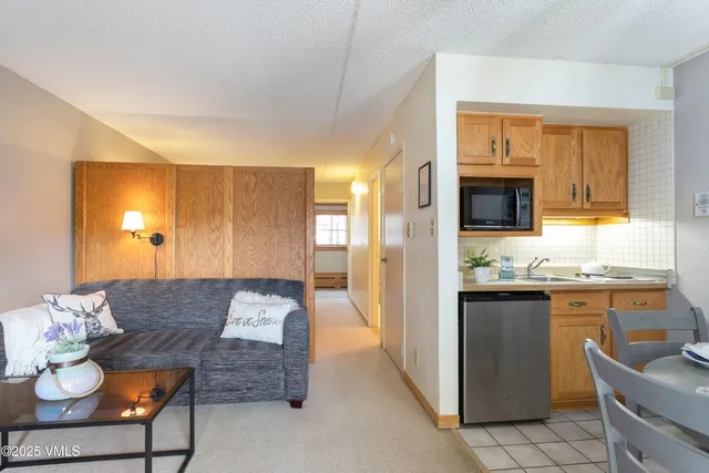 a living room with stainless steel appliances granite countertop furniture and a kitchen view