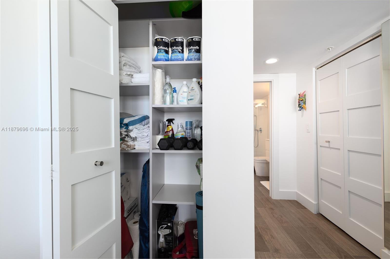 90 Alton Road, Unit 1703 Miami Beach, FL 33139 - Photo 14 of 48 a room with white cabinets and wooden floor