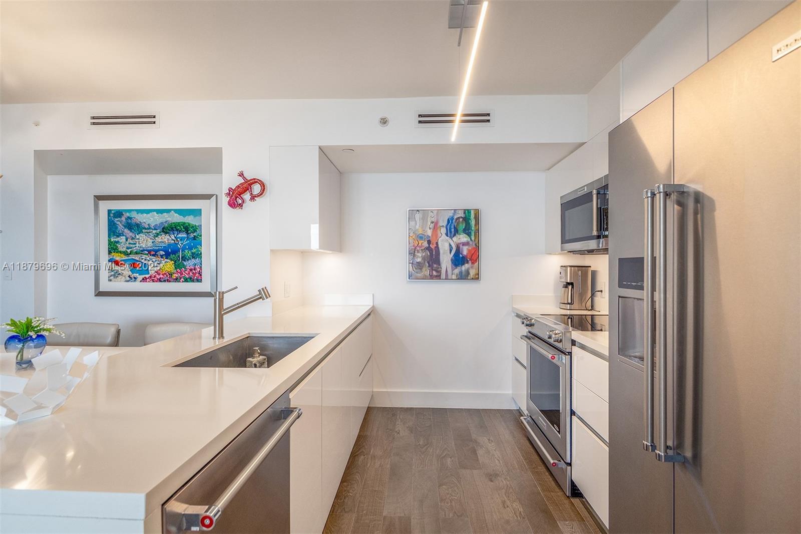 90 Alton Road, Unit 1703 Miami Beach, FL 33139 - Photo 4 of 48 a kitchen with stainless steel appliances a sink a stove a refrigerator and cabinets