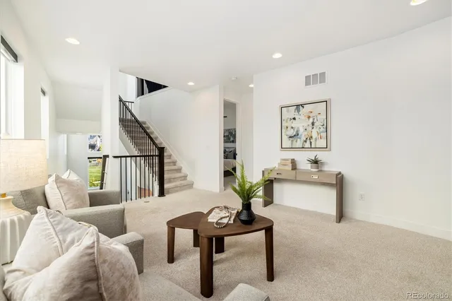 a view of staircase with lots of frames on wall and wooden floor