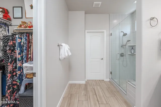 a view of a hallway with wooden floor and closet area