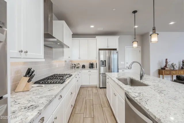 a kitchen with stainless steel appliances granite countertop a sink stove and refrigerator