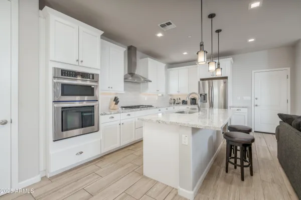a kitchen with kitchen island a white counter top space cabinets and stainless steel appliances