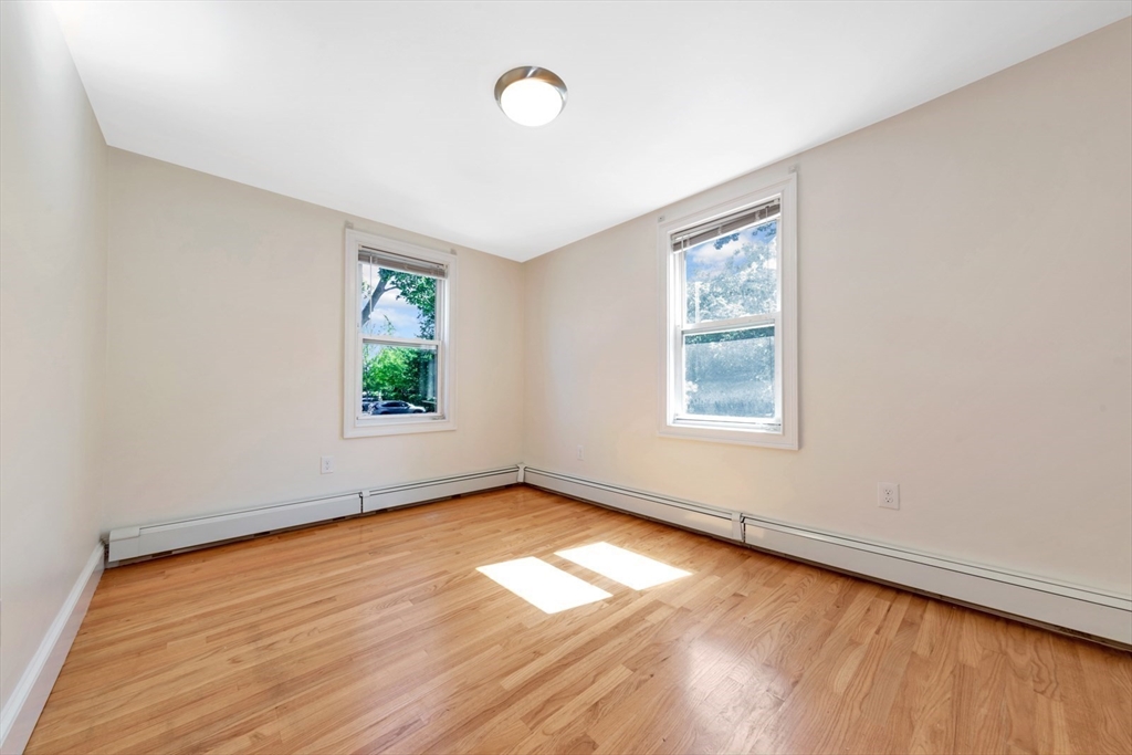 4 School Street, Unit 2 Boston, MA 02119 - Photo 12 of 25 an empty room with wooden floor and windows