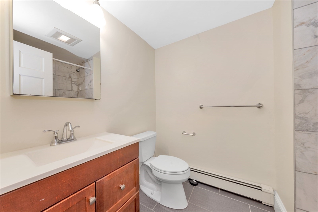 4 School Street, Unit 2 Boston, MA 02119 - Photo 16 of 25 a bathroom with a sink mirror vanity and toilet