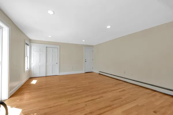 a view of an empty room with wooden floor