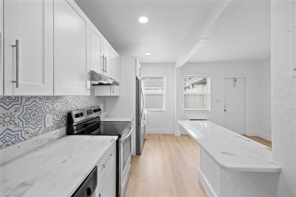 412 Southeast 16th Street, Unit 2 Fort Lauderdale, FL 33316 - Photo 4 of 20 a kitchen with stainless steel appliances granite countertop a refrigerator a sink and white cabinets