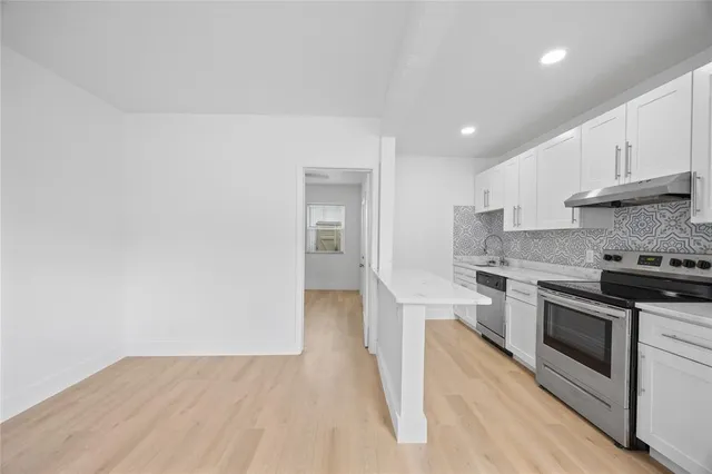 a kitchen with stainless steel appliances granite countertop a stove a sink and a refrigerator