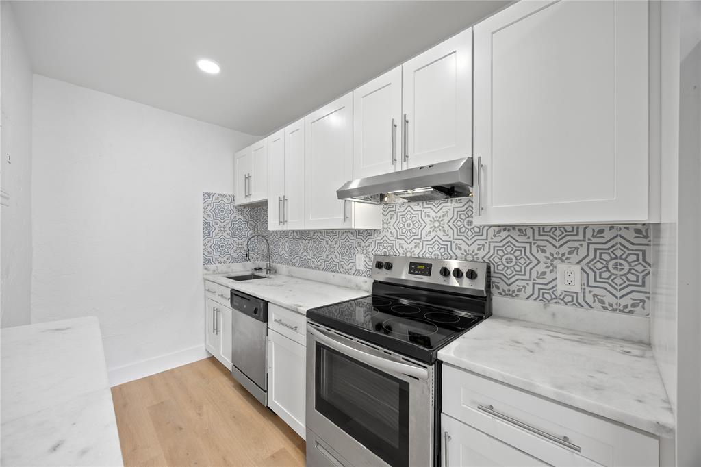 412 Southeast 16th Street, Unit 2 Fort Lauderdale, FL 33316 - Photo 6 of 20 a kitchen with a stove and white cabinets