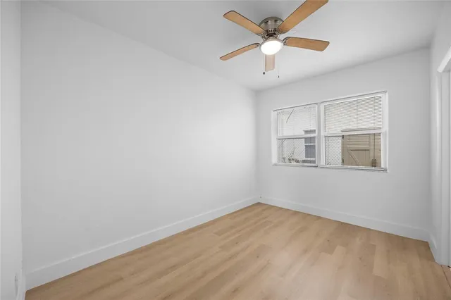 a view of a big room with wooden floor and a ceiling fan