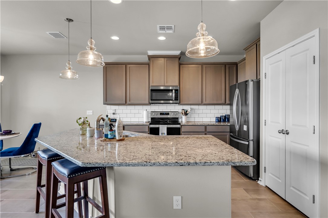 1033 Ocean Breeze Portland, TX 78374 - Photo 30 of 38 a kitchen with granite countertop stainless steel appliances and a refrigerator