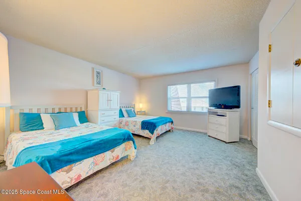 a bedroom with 2 bed and a flat screen tv