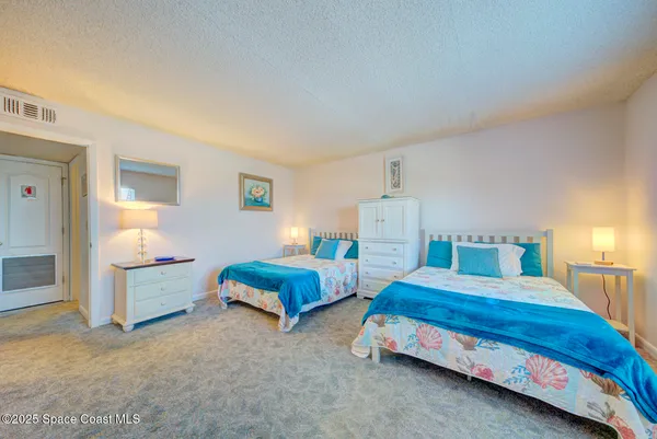 a bedroom with two beds and window