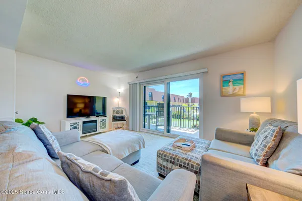 a living room with furniture a flat screen tv and a large window
