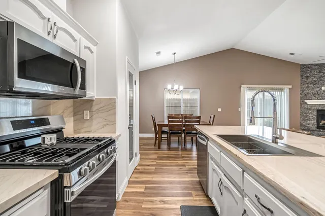 a kitchen with stainless steel appliances kitchen island granite countertop a stove and a sink