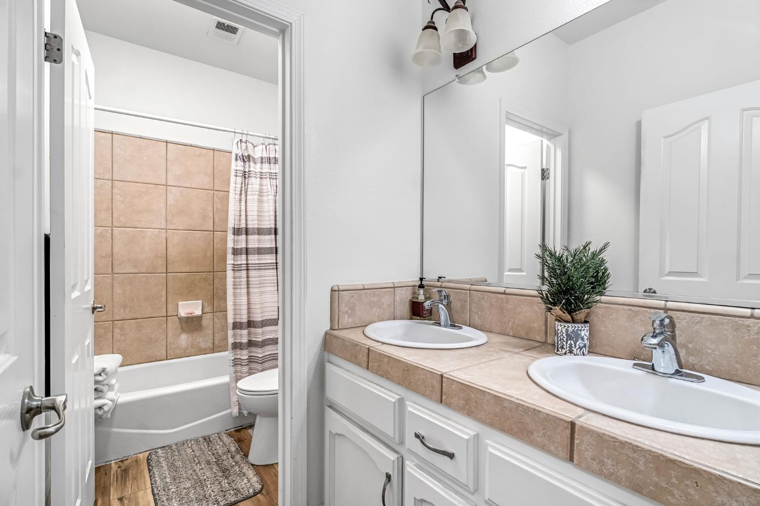 2634 Marie Drive Madera, CA 93637 - Photo 19 of 32 a bathroom with a granite countertop sink and a mirror