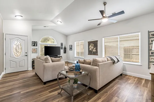 a living room with furniture a large window and a fireplace
