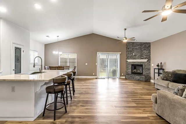 a view of a livingroom with furniture a fireplace a chandelier and wooden floor