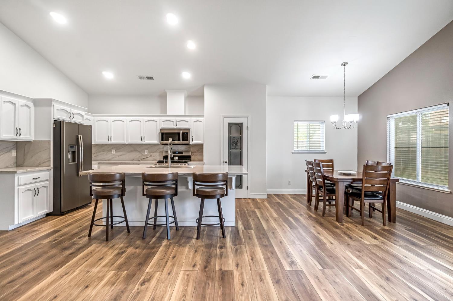 2634 Marie Drive Madera, CA 93637 - Photo 10 of 32 a dining room with stainless steel appliances kitchen island granite countertop a dining table chairs and granite counter tops