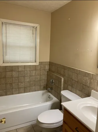 a bathroom with a sink a toilet and bathtub
