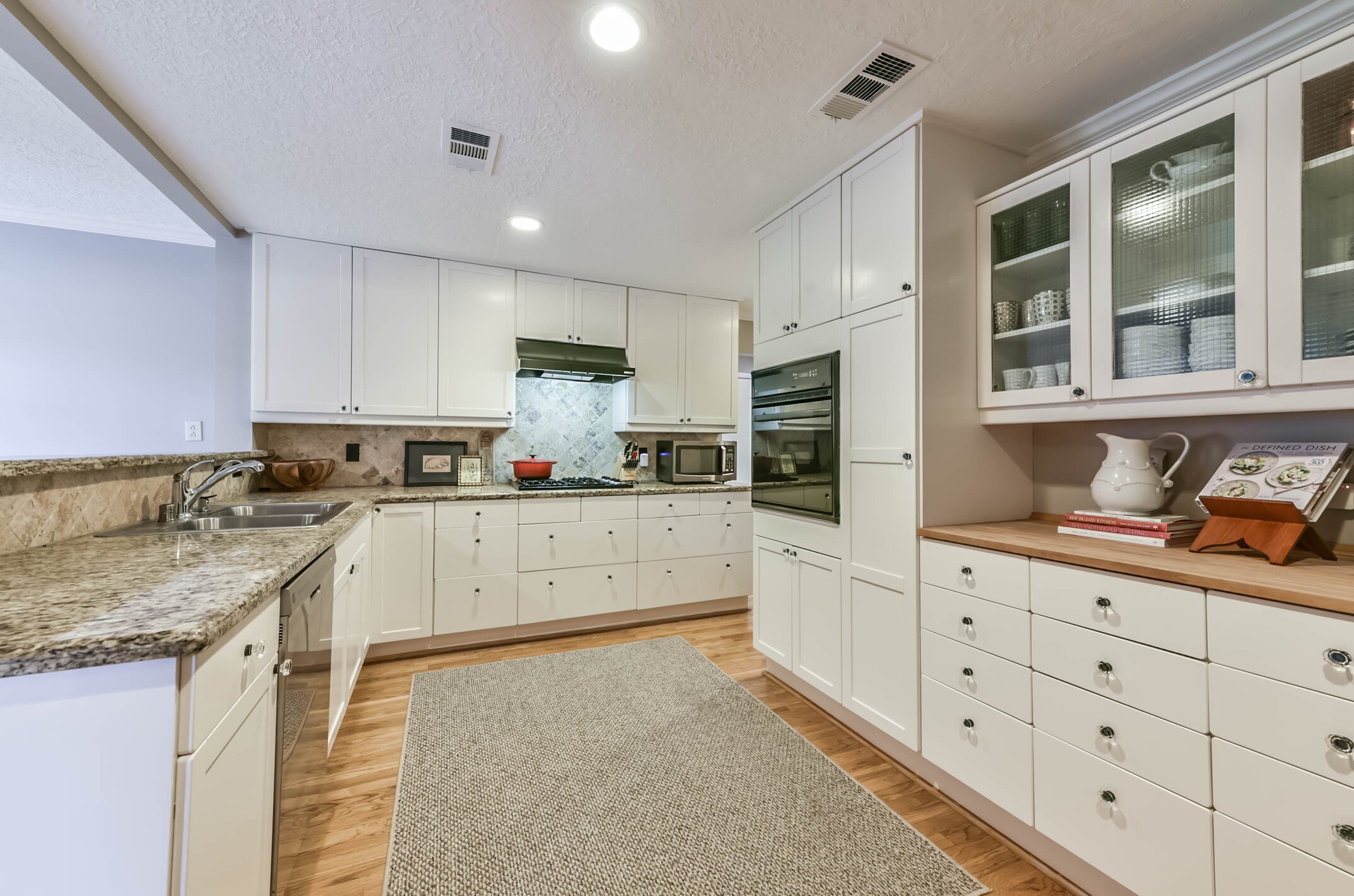 906 Bay Oaks Road Houston, TX 77008 - Photo 13 of 26 Glass inset cabinets and the butcher block counter give an extra special touch to this kitchen.