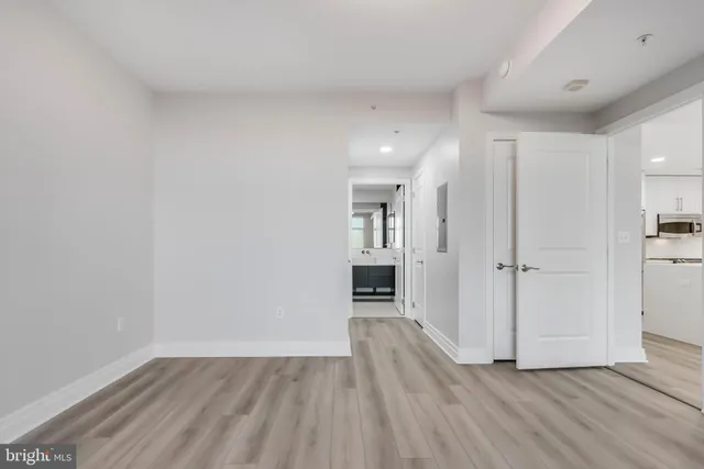 a view of a room with wooden floor and a kitchen
