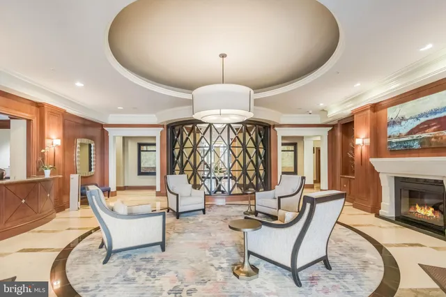 a living room with furniture a fireplace and a chandelier