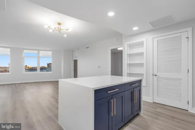 a kitchen with a wooden floor and cabinets