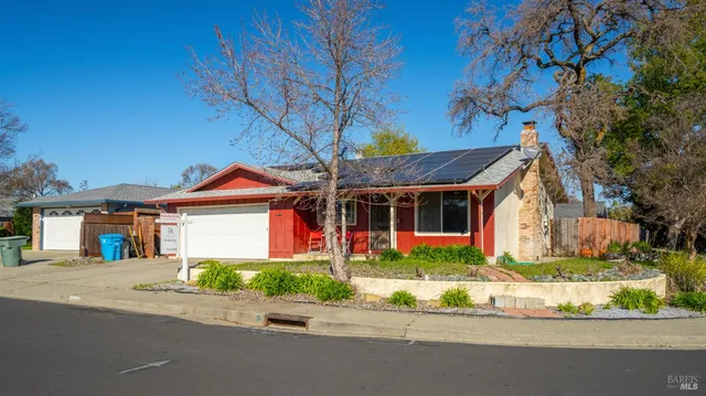 a front view of a house with a yard and potted plants