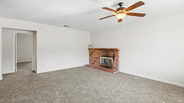 an empty room with closet and a ceiling fan