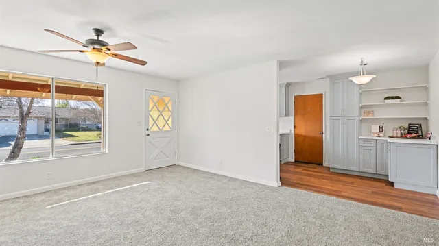 a view of empty room with window and ceiling fan