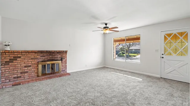 an empty room with windows and fireplace