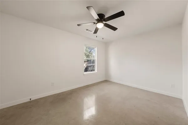 an empty room with a window and a fan