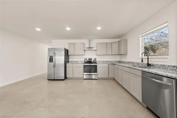 a kitchen with stainless steel appliances a refrigerator sink and white cabinets