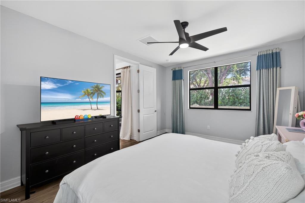 7845 Bristol Circle Naples, FL 34120 - Photo 15 of 31 a bedroom with a bed and a flat tv screen on dresser