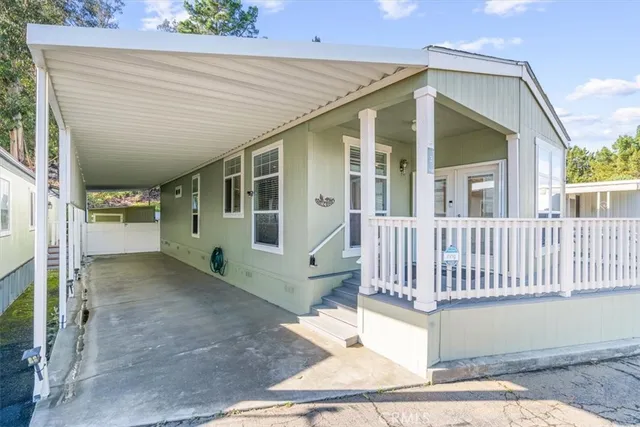 a view of a house with a small yard and wooden floor and fence