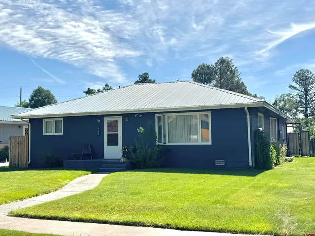 a view of a yard in front of a house with large trees