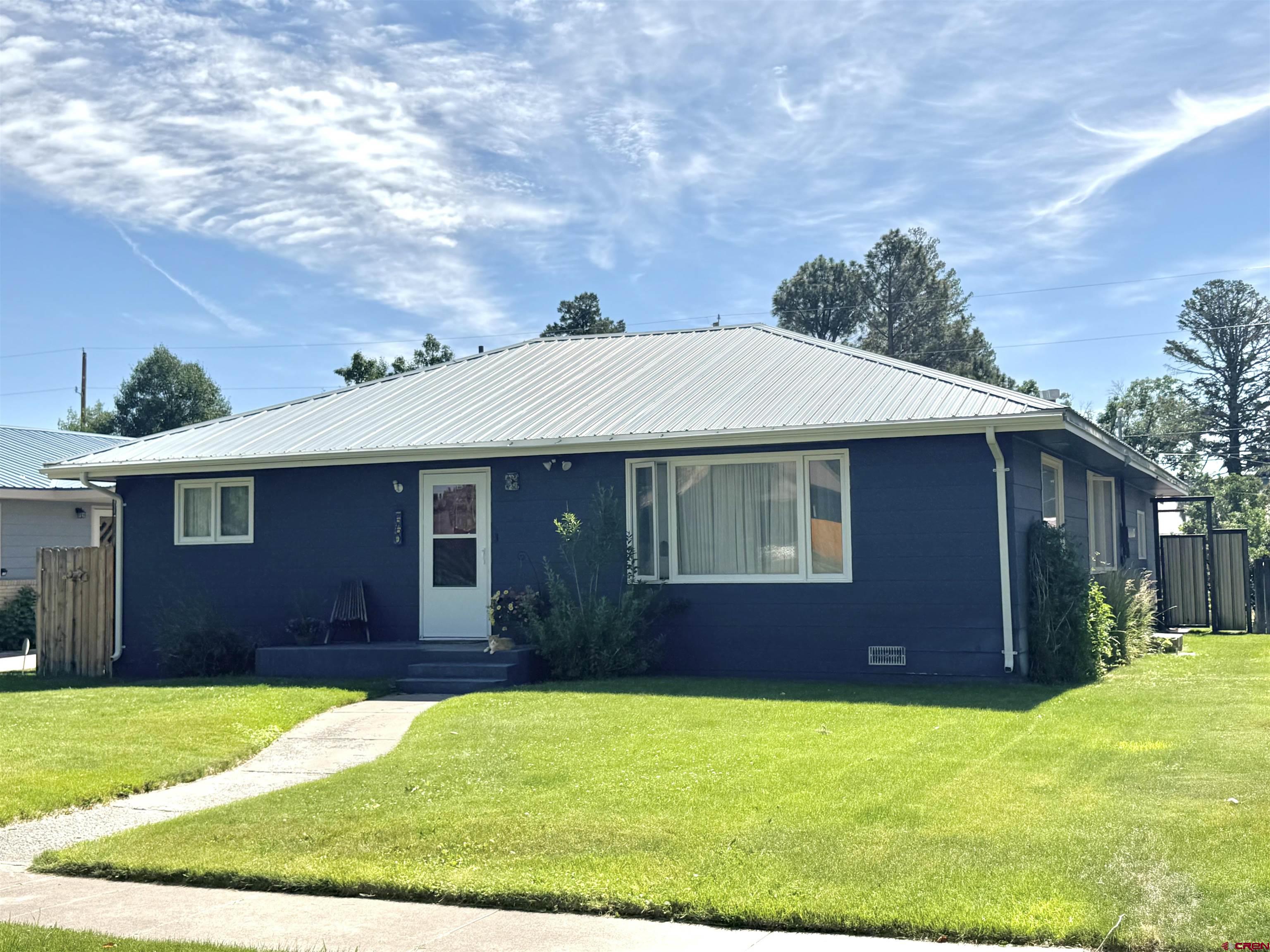 660 Columbia Avenue Del Norte, CO 81132 - Photo 1 of 31 a view of a yard in front of a house with large trees