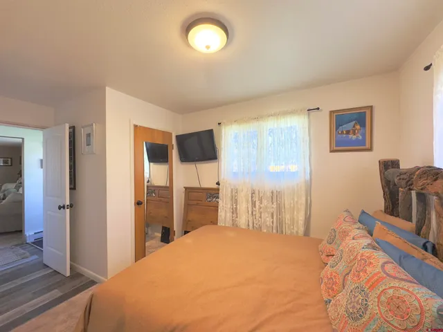 a bedroom with a bed and dresser with mirror