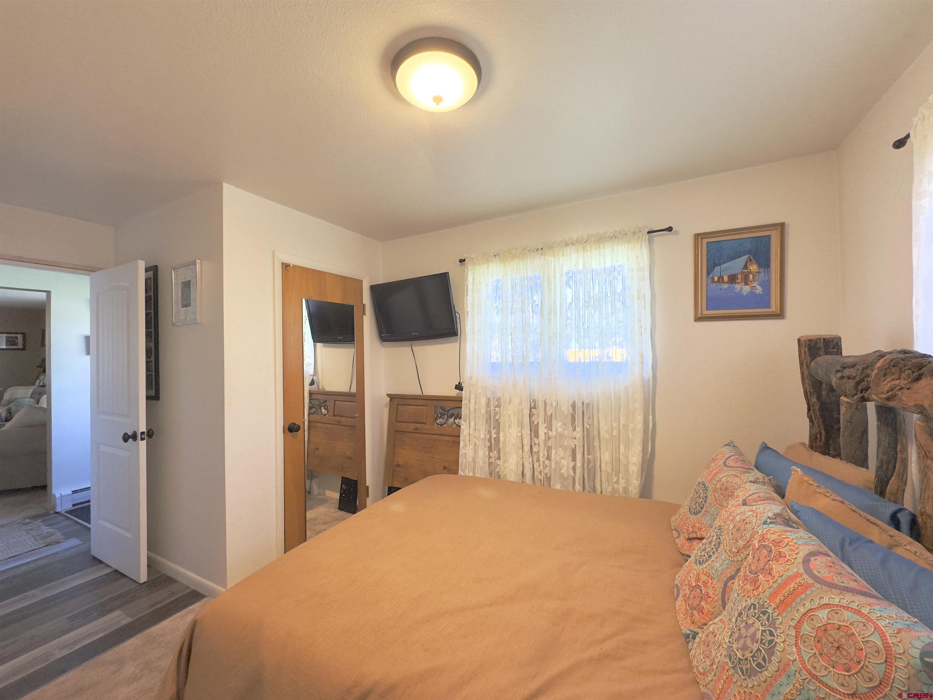 660 Columbia Avenue Del Norte, CO 81132 - Photo 14 of 31 a bedroom with a bed and dresser with mirror