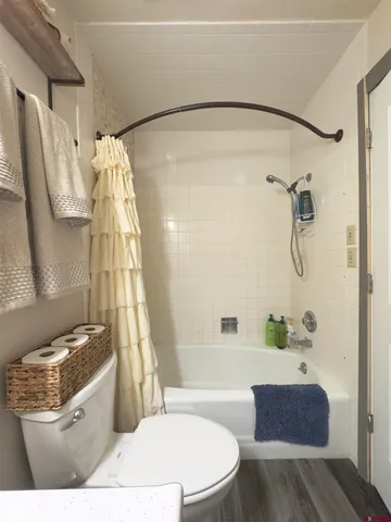 a bathroom with a granite countertop bathtub sink vanity mirror and toilet