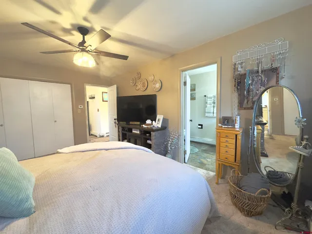 a bedroom with a bed and a mirror on the dresser