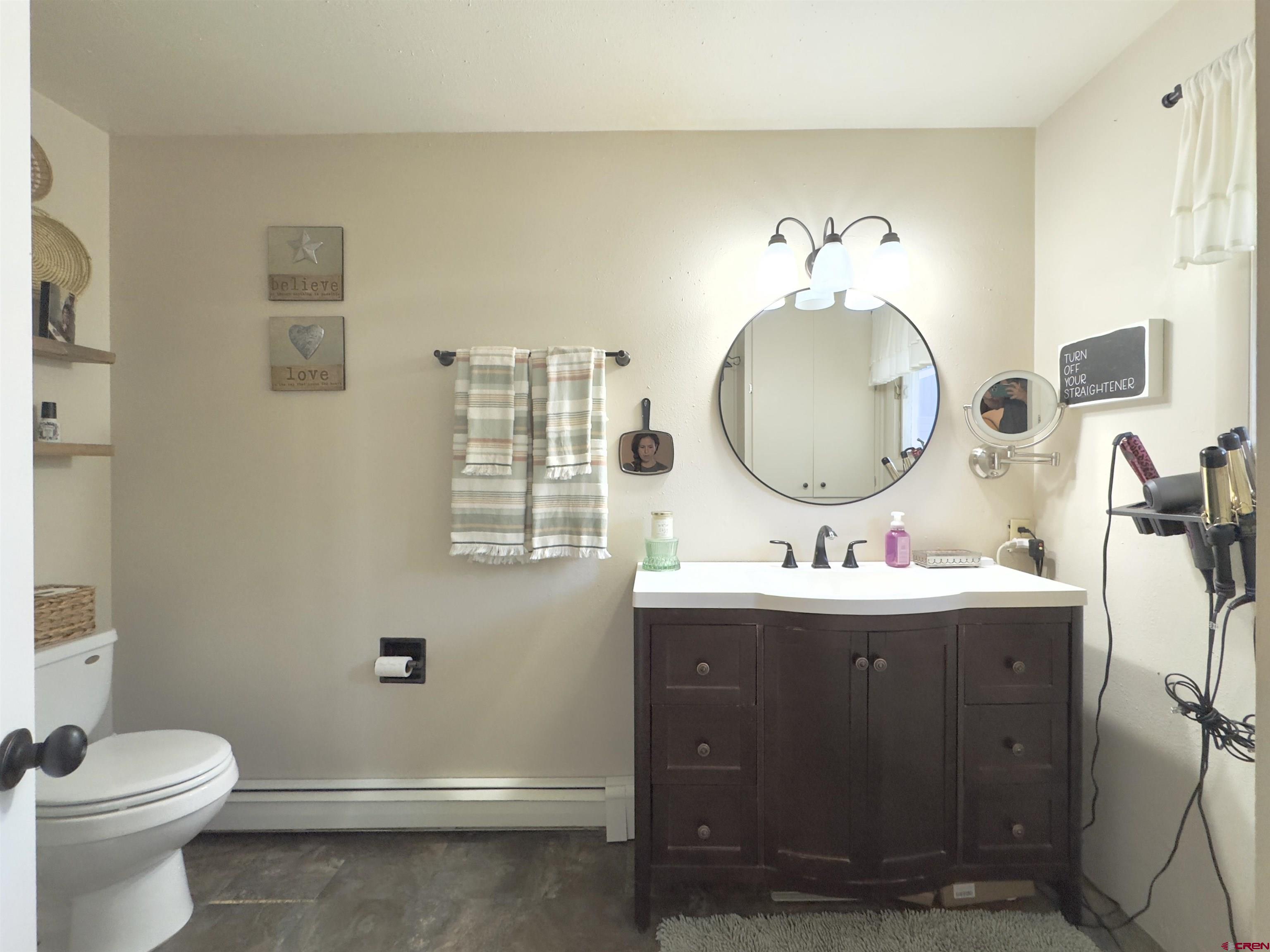 660 Columbia Avenue Del Norte, CO 81132 - Photo 19 of 31 a bathroom with a toilet sink and mirror