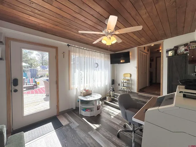 a living room with furniture a flat screen tv and a large window