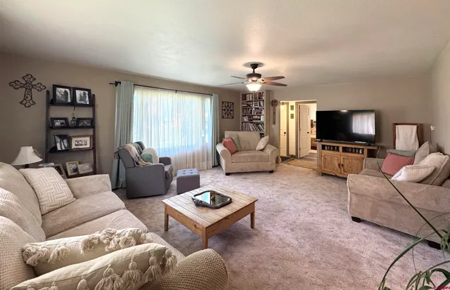 a living room with furniture a flat screen tv and a window