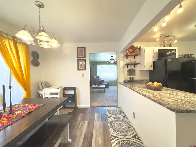 a kitchen with stainless steel appliances granite countertop a sink dishwasher and a stove with wooden floor