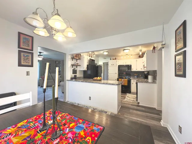 a living room with kitchen island furniture and a chandelier